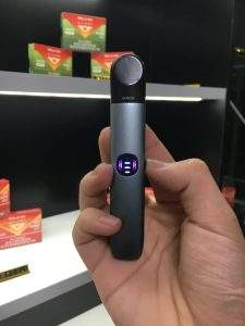 手持 RELX 悅刻六代主機黑色款實拍，展現精緻工業設計與金屬質感