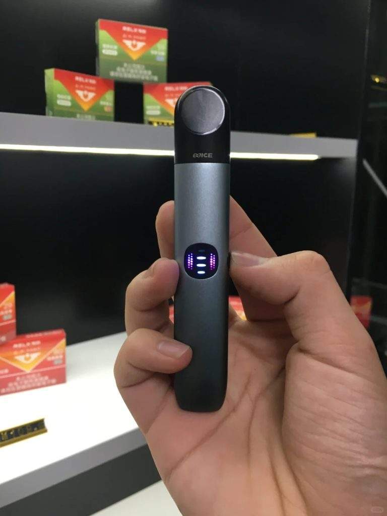 手持 RELX 悅刻六代主機黑色款實拍，展現精緻工業設計與金屬質感